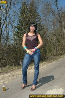 Teen brunette pissing on asphalt path outdoor