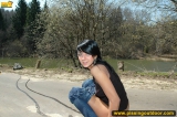 Teen brunette pissing on asphalt path outdoor
