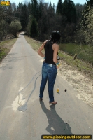 Teen brunette pissing on asphalt path outdoor