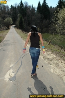 Teen brunette pissing on asphalt path outdoor